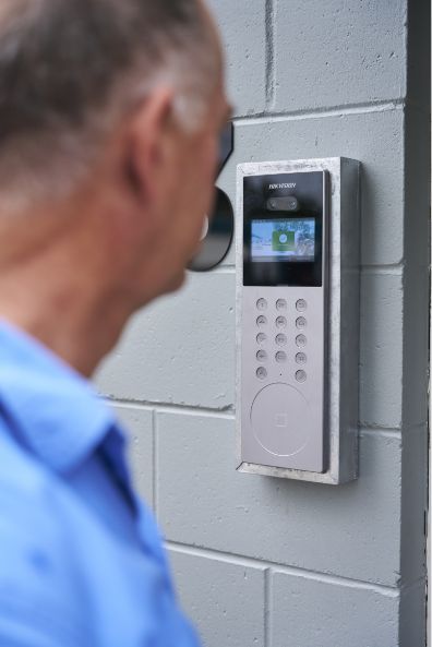 Man looking at security system device on wall